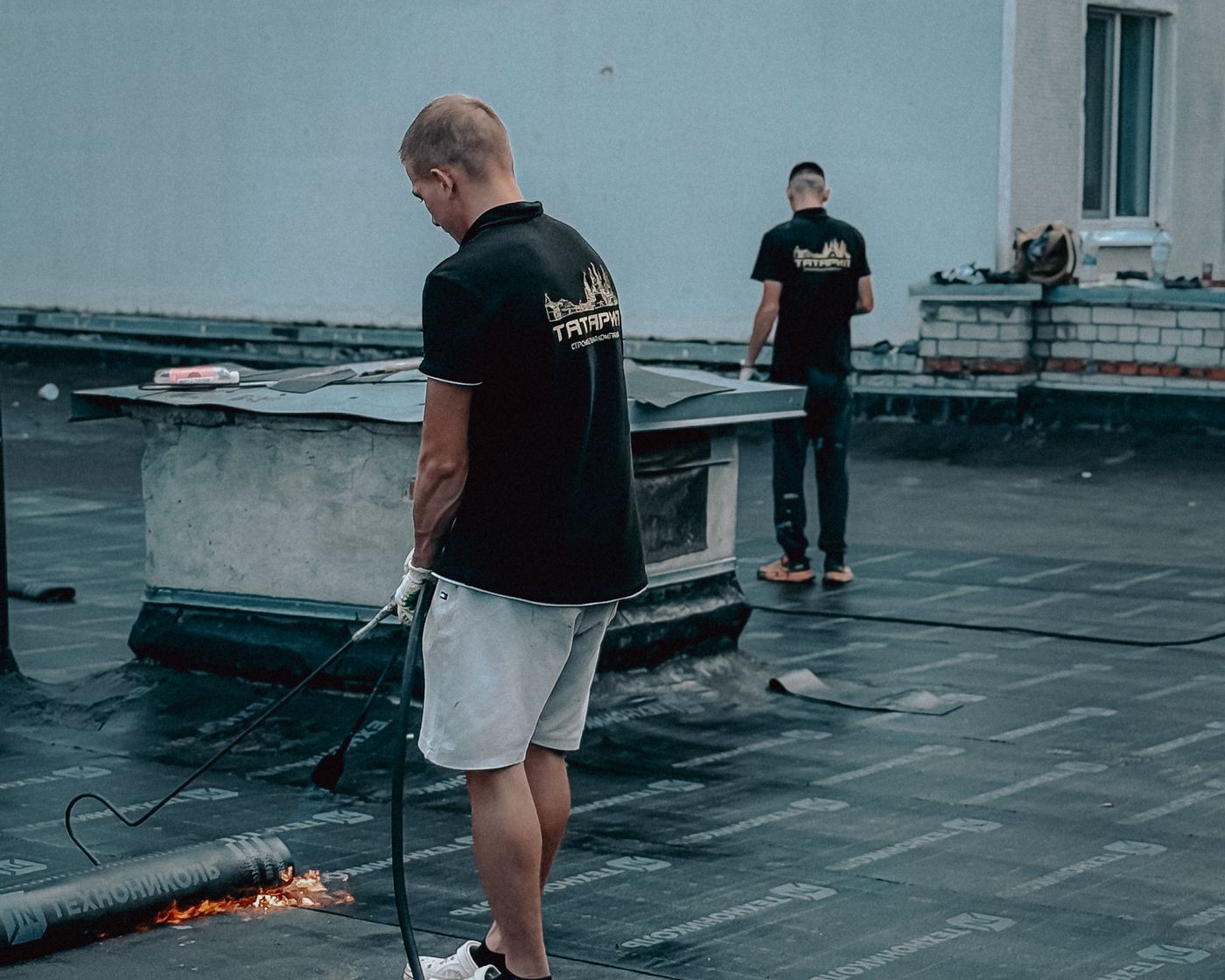 Roofing contractors working on a flat roof