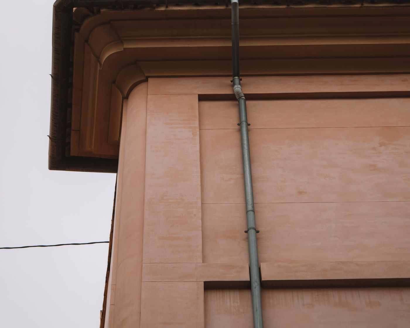 Underside of a roof overhang with a downspout at the corner