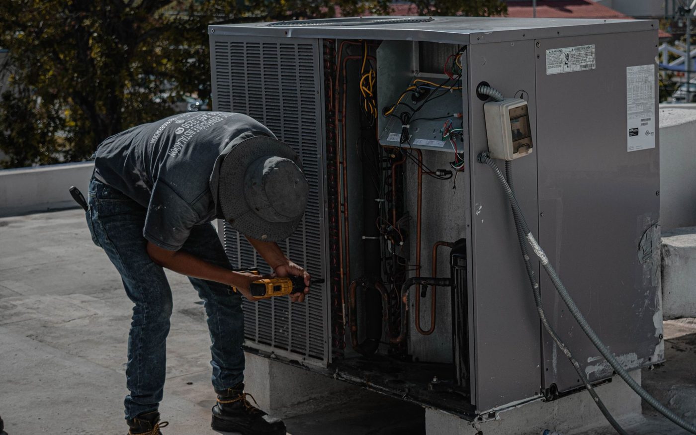 Technician working on a rooftop air conditioning unit