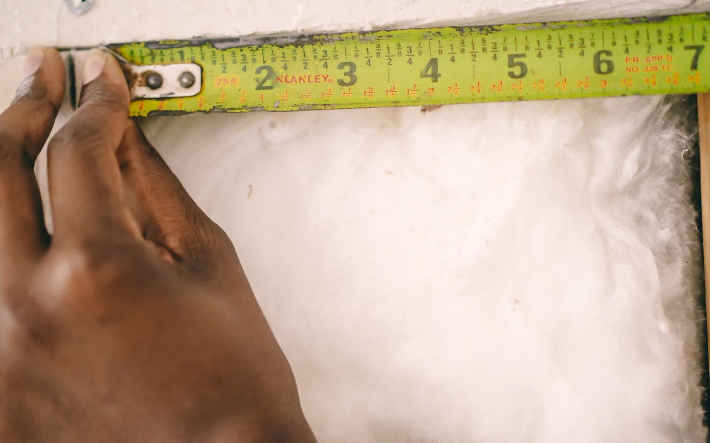 Tape measure laid across a sheet of insulation