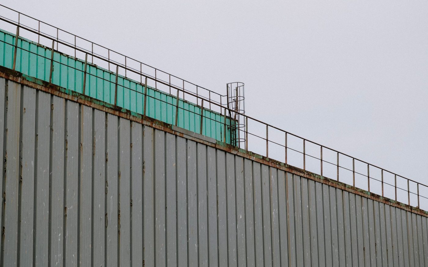Ribbed metal wall with a rail running along the roofline