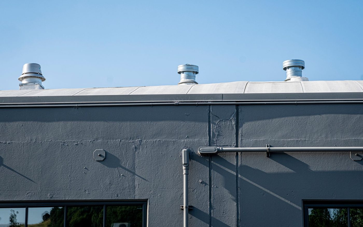 Rooftop vents along the top of a gray industrial building