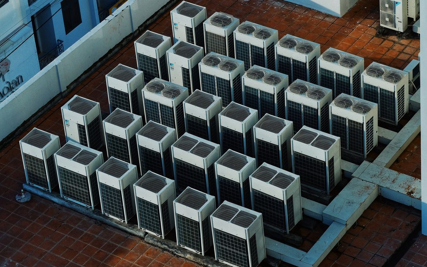 Rows of rooftop air conditioning units on a flat roof