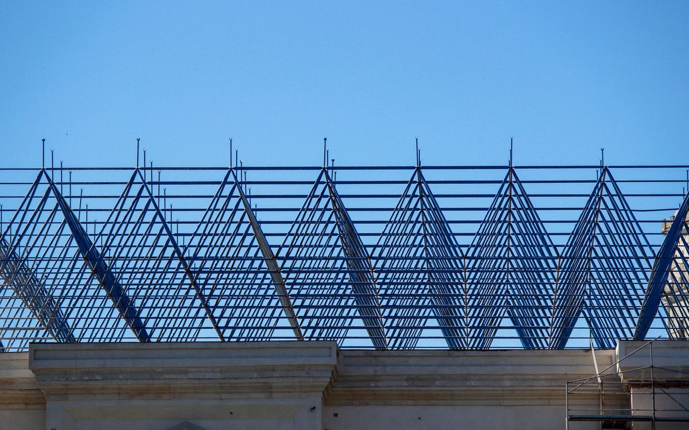 Steel roof framing against a blue sky