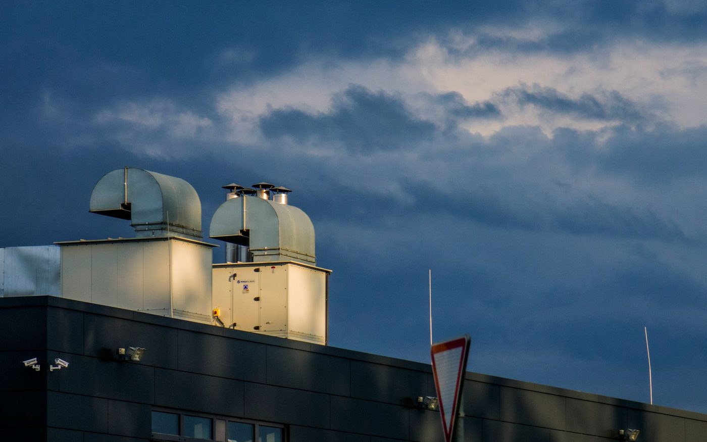 Two rooftop ventilation housings under a dark sky