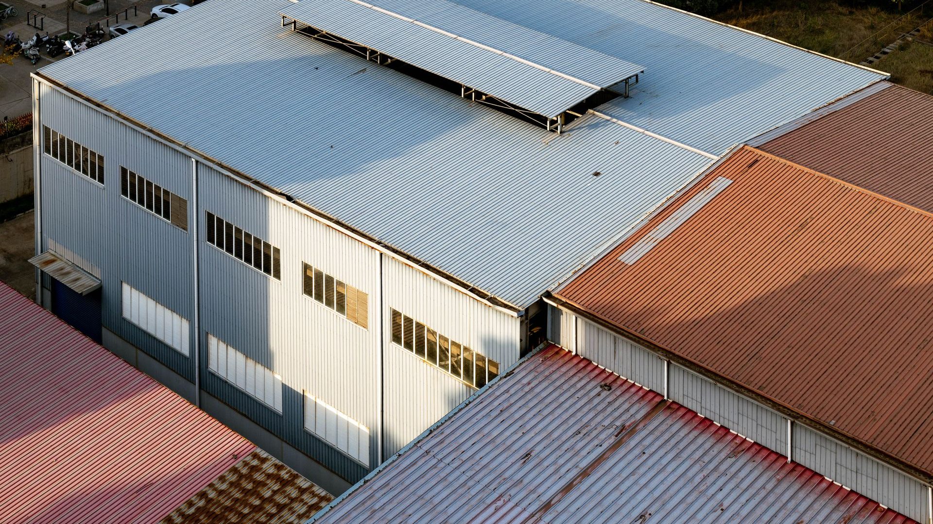 Industrial building with a white roof and skylights, seen from above
