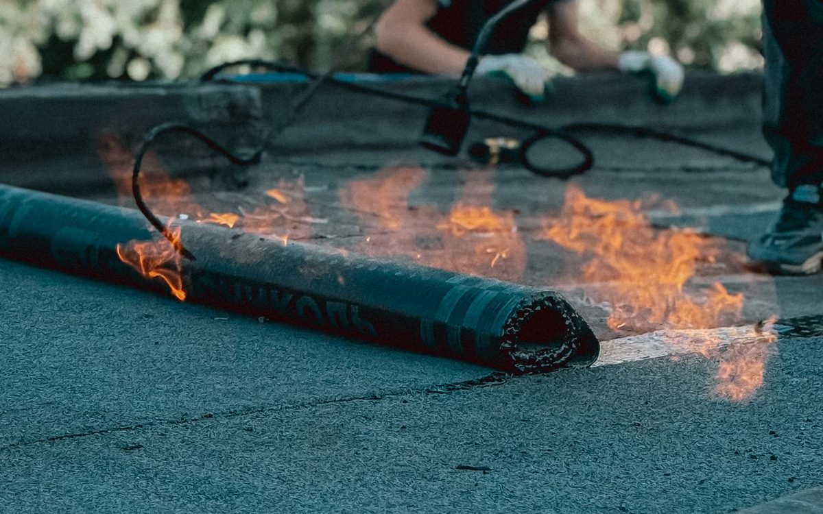 Roll of torch-down membrane with a flame running along it