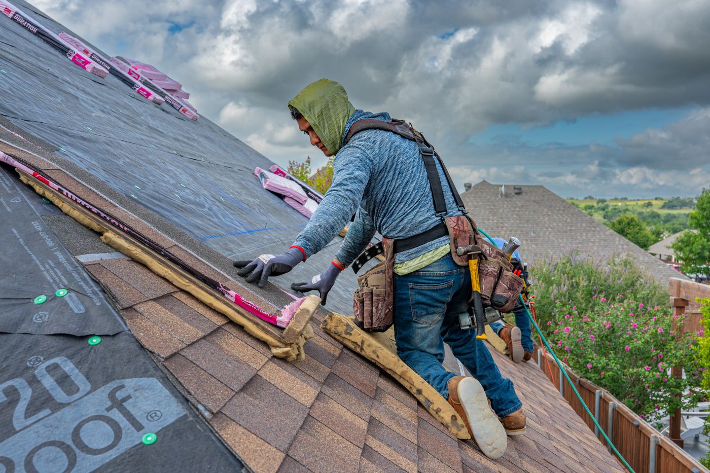 Roofer in a safety harness working across a pitched roof