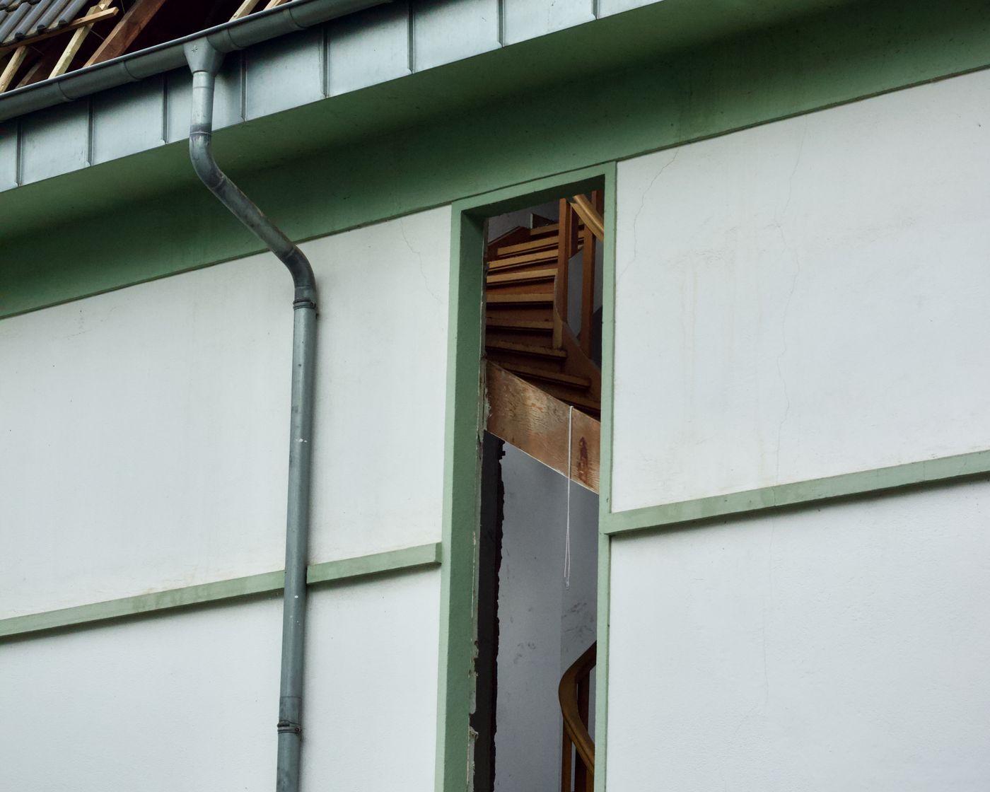 House exterior with a damaged wall and window