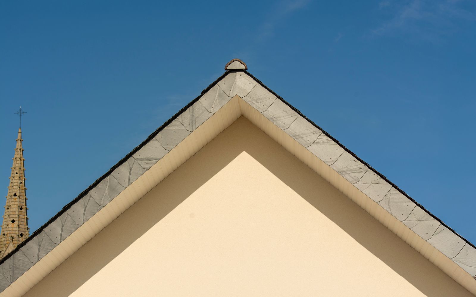 Gable fascia and soffit line against a blue sky