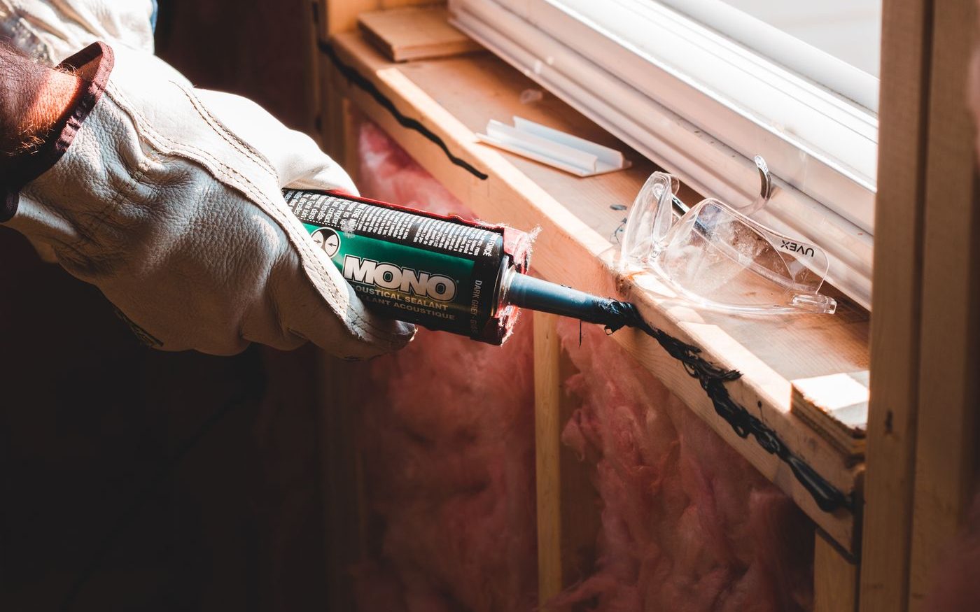 Gloved hand running sealant along a seam