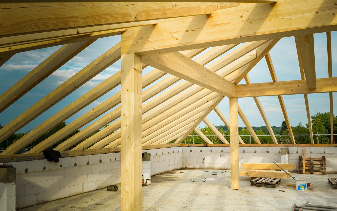 Wooden roof trusses on an unfinished building under a clear sky