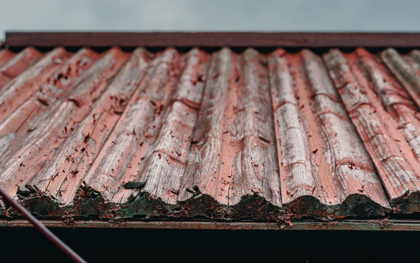 Rusted corrugated metal roof under a cloudy sky