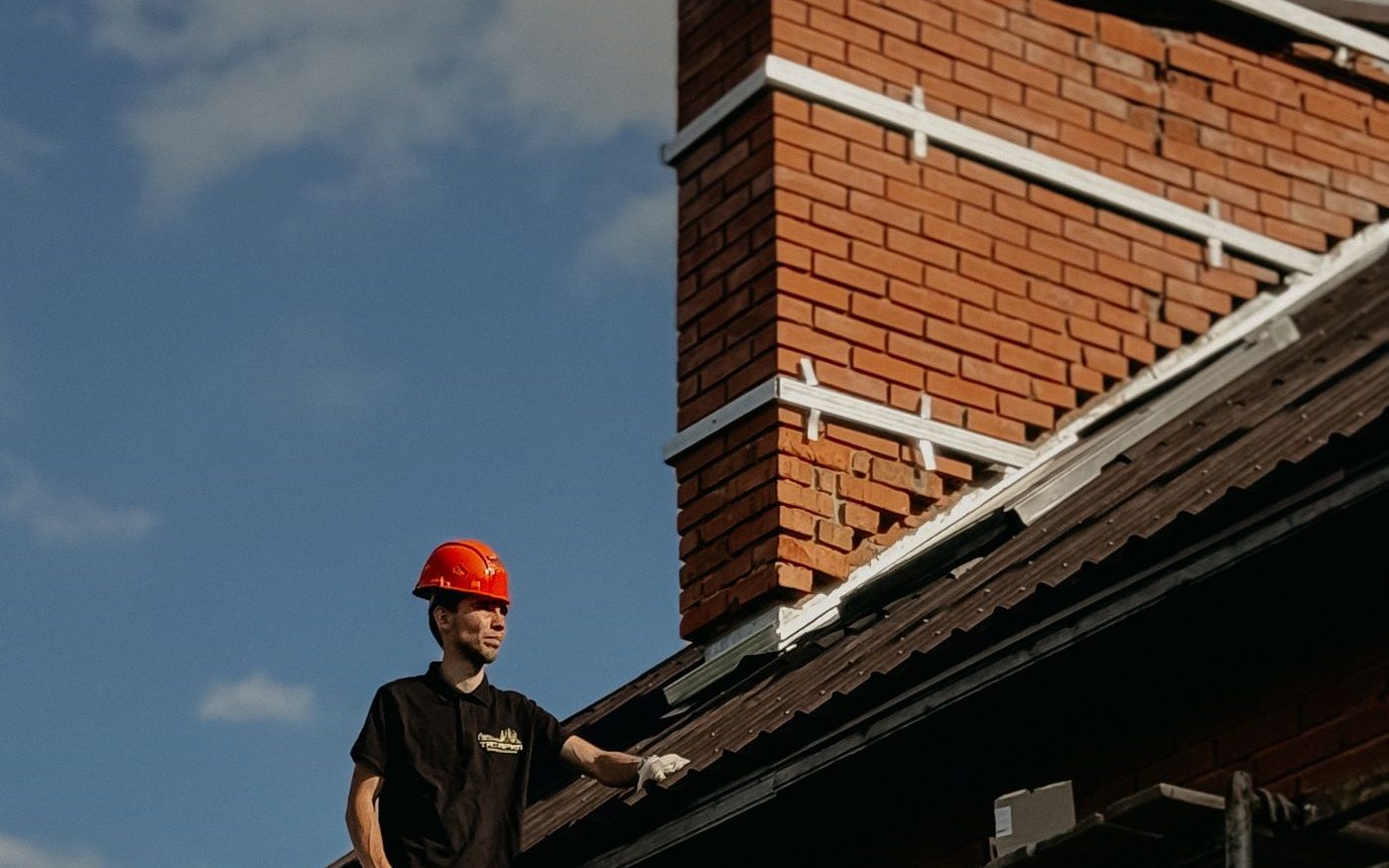 Worker on scaffolding beside a brick chimney