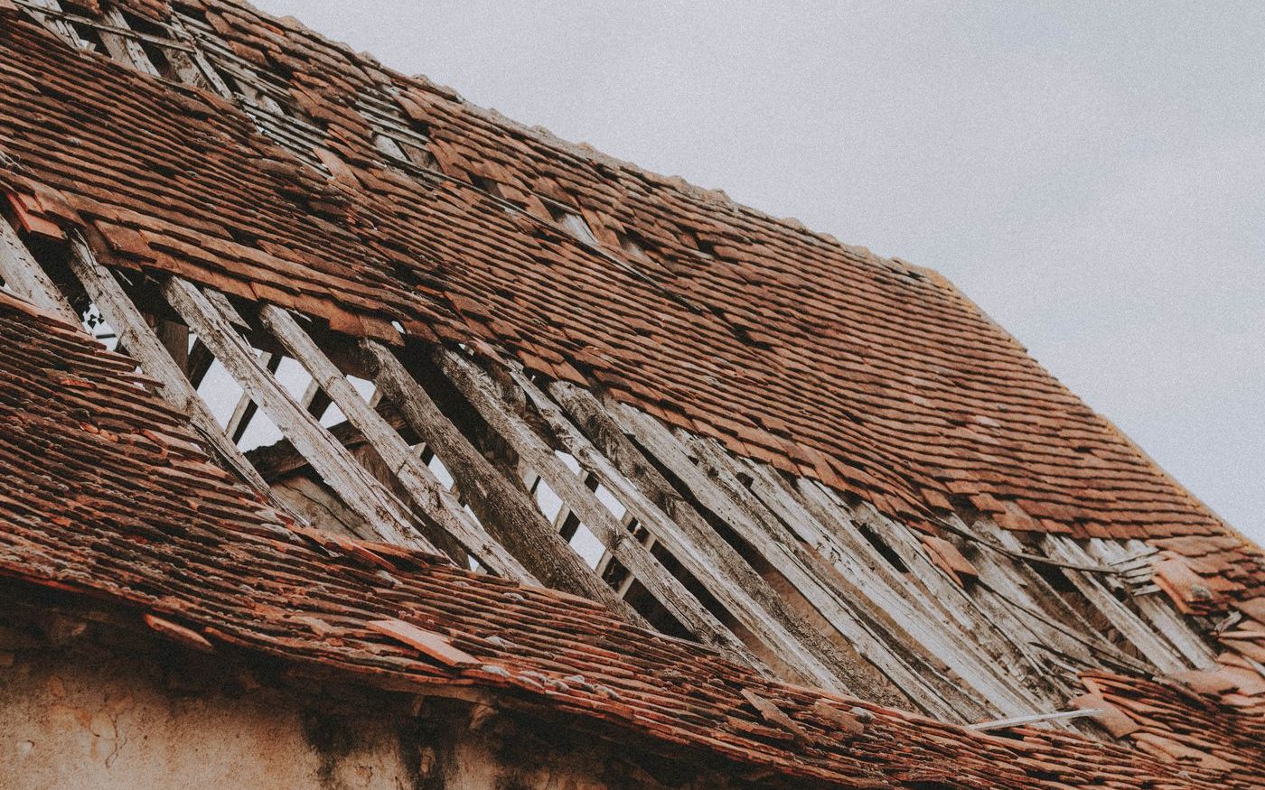 Old roof with shingles missing and the deck showing through