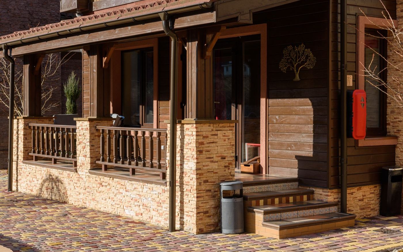 Wooden house with a covered porch and a stone base