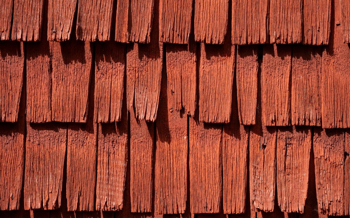 Red-stained wooden shakes in overlapping rows