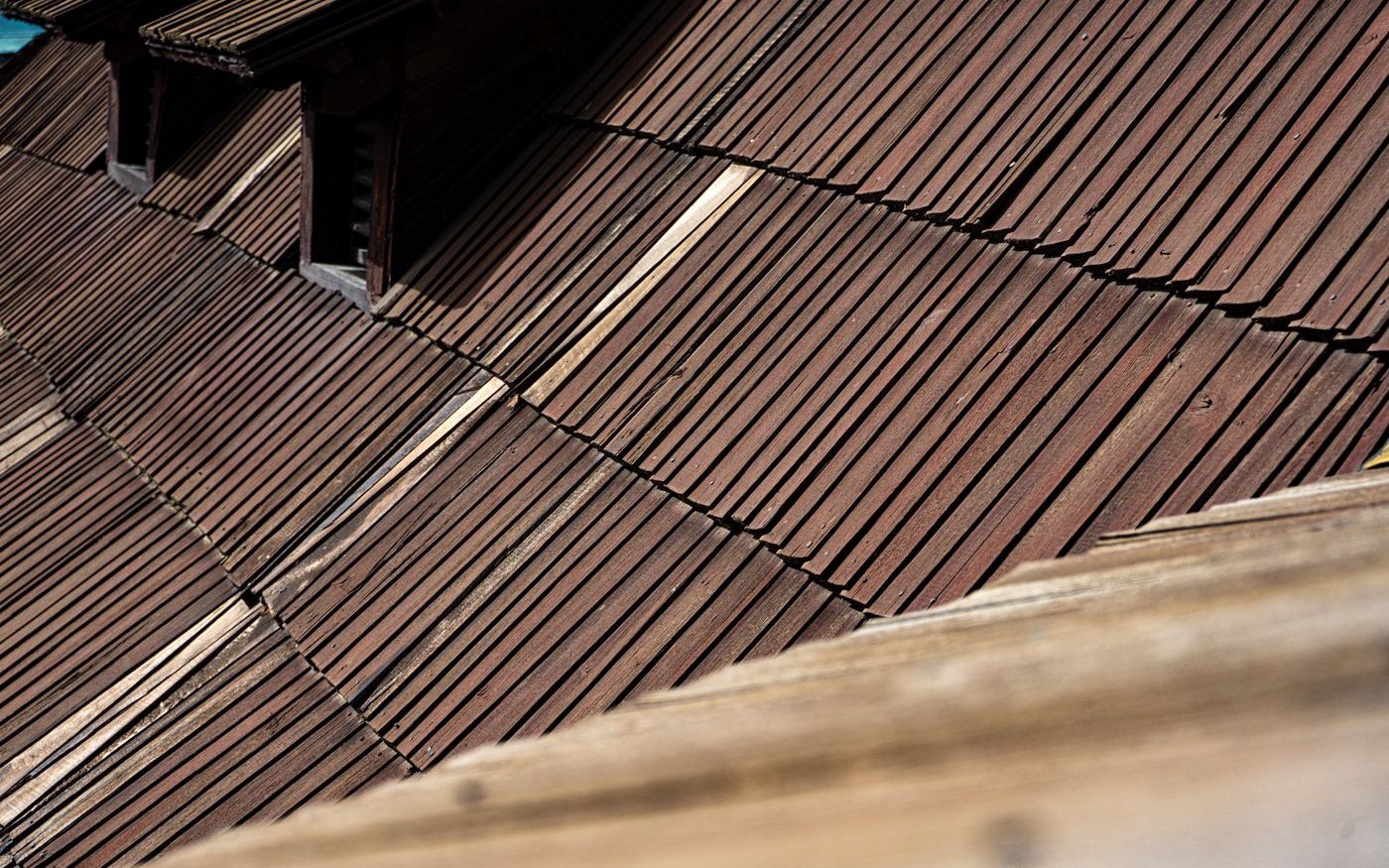 Brown wooden shingles running down a roof slope