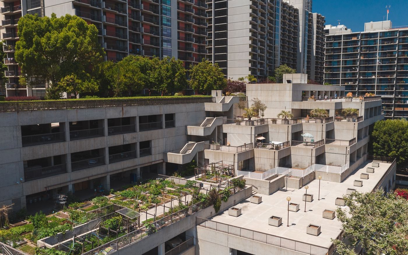 Planted roof terraces on a concrete building among high-rises