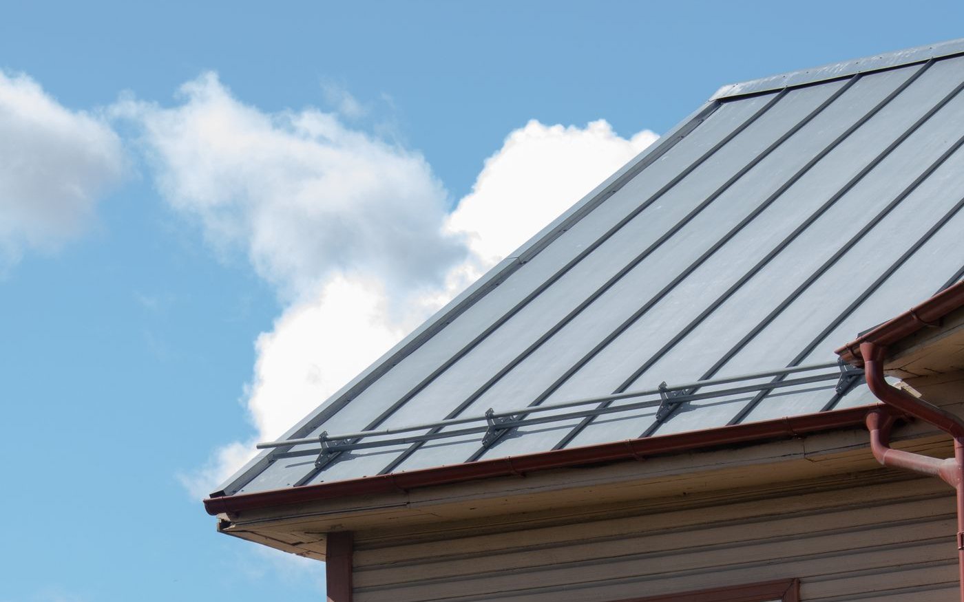 Gray standing seam roof on a wooden house