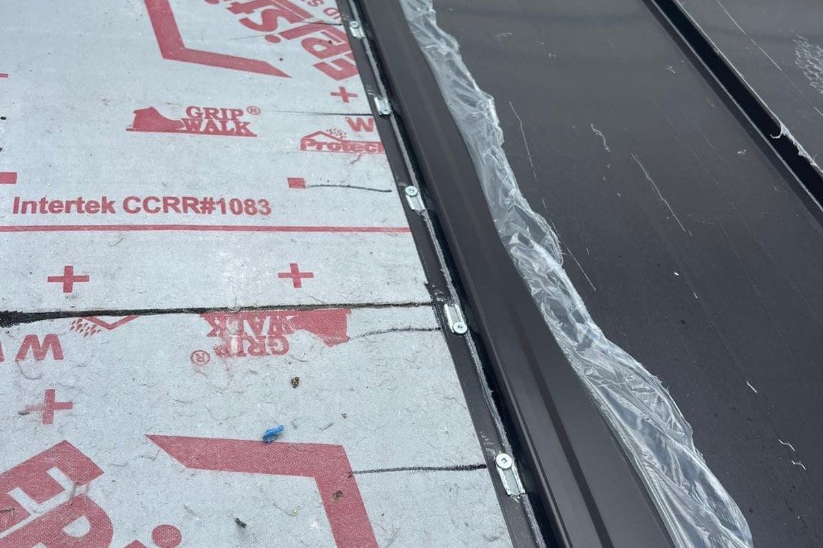 Synthetic underlayment and a metal valley flashing on a roof deck